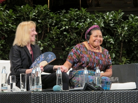 Die Friedensnobelpreisträgerinnen Jody Williams und Rigoberta Menchú Tum sitzen auf einer Couch und geben sich die Hand, sie sind Freundinnen